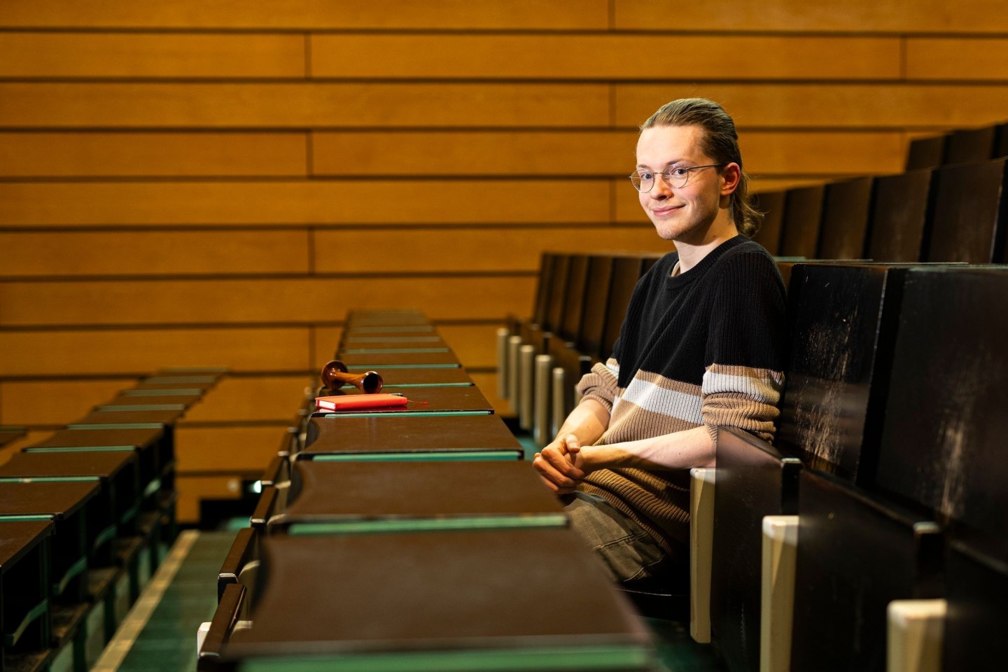 Gabriel Backer, Student der Hebammenwissenschaft an der Medizinischen Hochschule Hannover. Vor ihm liegt ein Pinard-Rohr zum Abhören von fetalen Herztönen.