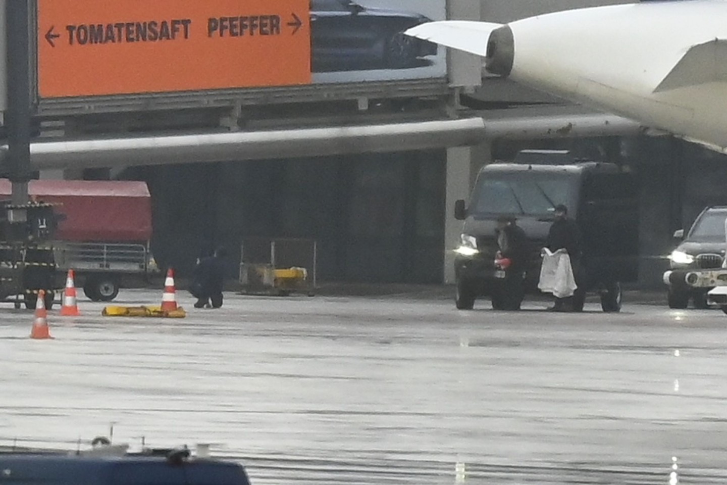 Der Geiselnehmer (l) kniet mit seinem Kind auf dem Boden - ein Polizeibeamter bringt eine Decke.